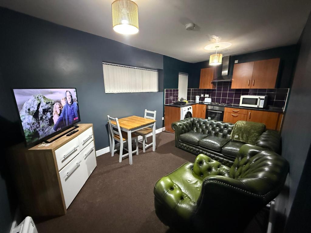 a living room with a couch and a tv and a kitchen at Dudley Retreat in Dudley