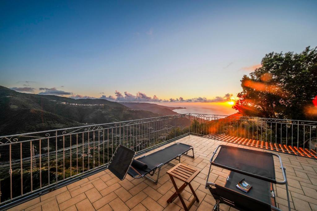 a patio with a table and chairs and a view of the ocean at Caliante in Piraino