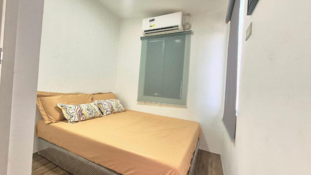 a small room with a small bed with a window at Phirst Park Homes Baliwag in Baliuag