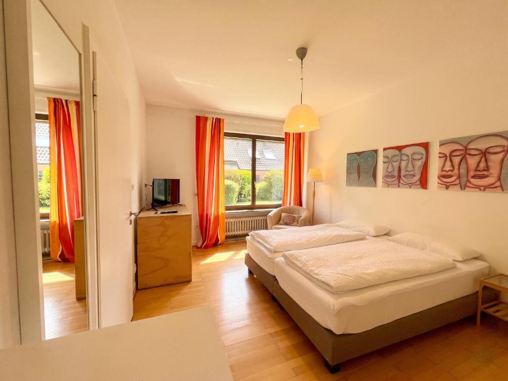 a bedroom with a bed and a window with orange curtains at Moderne Ferienwohnung Deichstrasse in Hennef