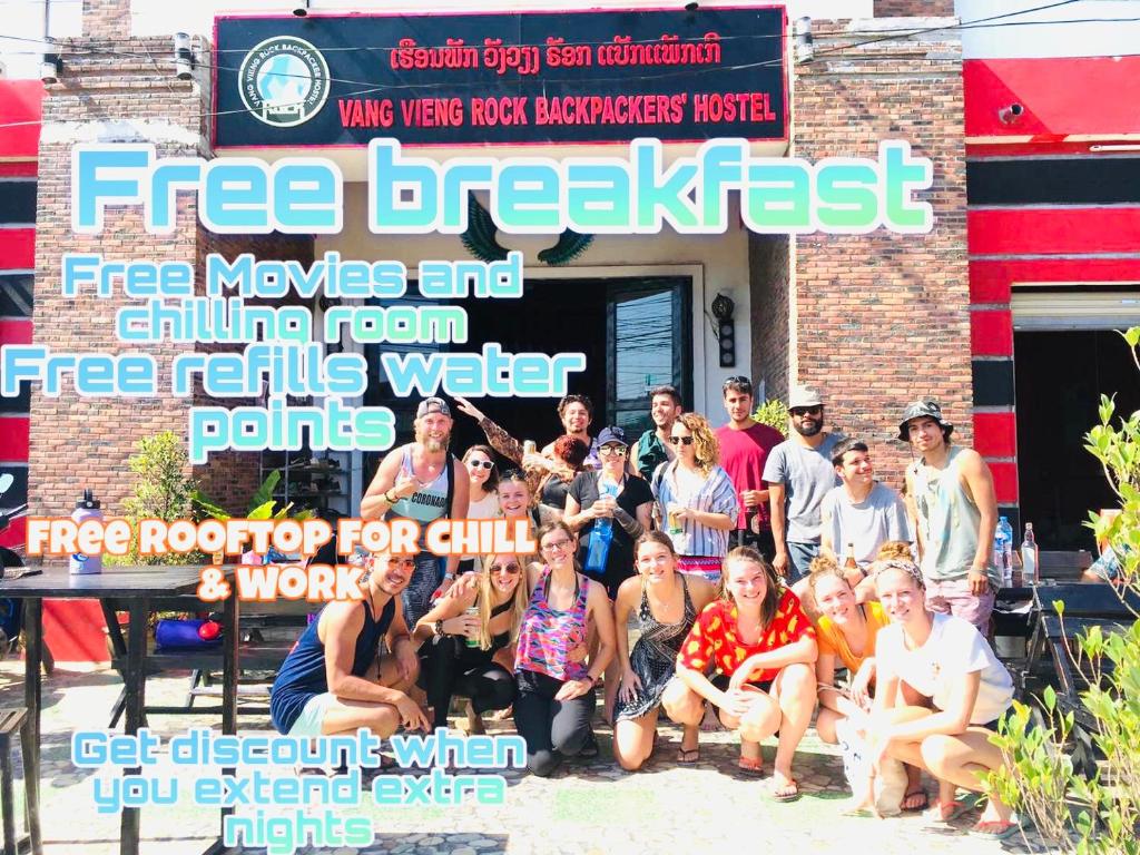 a group of people posing for a picture in front of a building at Rock Backpackers Central Hostel in Vang Vieng