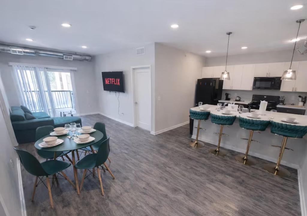 a living room with a table and chairs and a kitchen at Olive Oasis in Des Moines