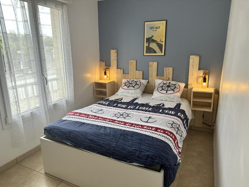 a bedroom with a bed with a wooden headboard at Résidence Fort de l'Eve - T2 à 380m plage M Hulot et commerces - St Marc sur Mer idéal famille proche La Baule P0rnichet avec parking privé in Saint-Nazaire