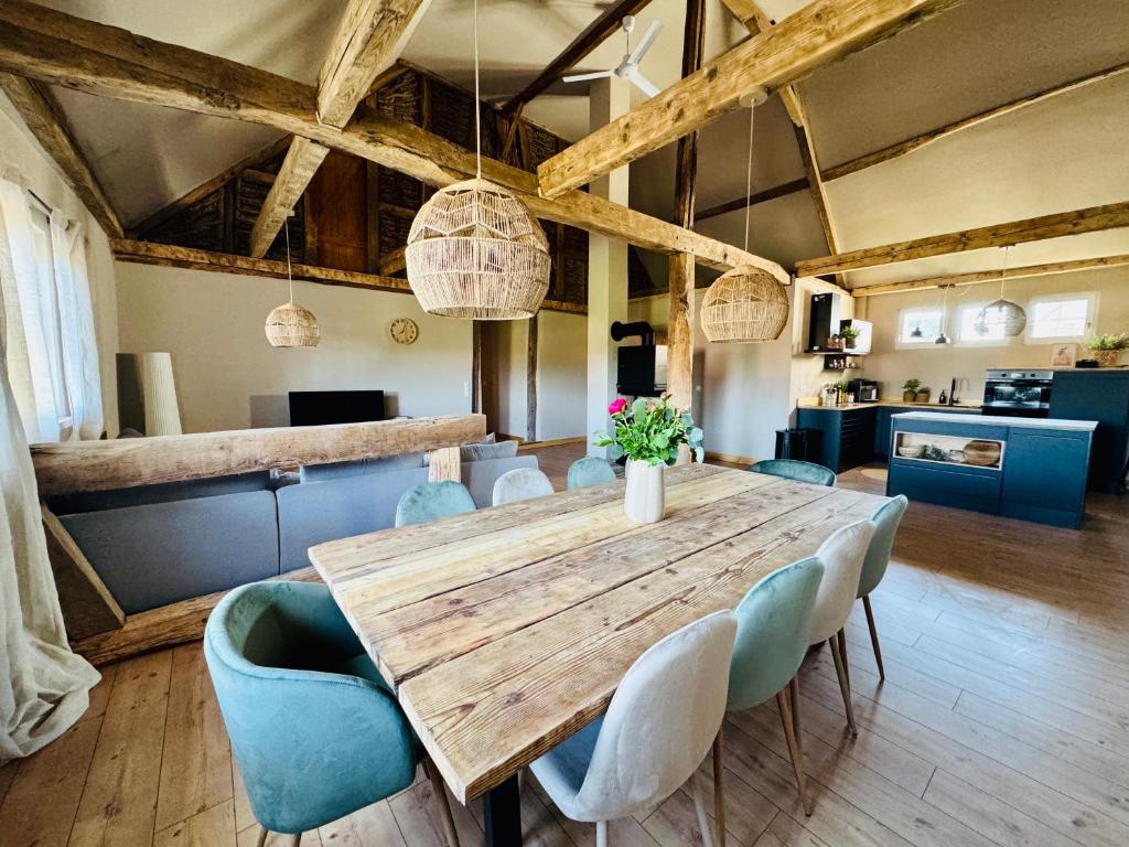 a dining room with a wooden table and blue chairs at Gude Zeit Ferienhaus in Mörsdorf
