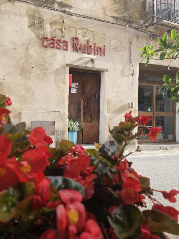 a store with red flowers in front of a building at Casa Rubini in Paestum