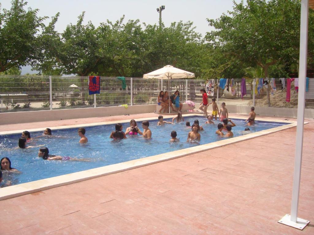 un grupo de personas en una piscina en El Mas de Xetà, en Luchente