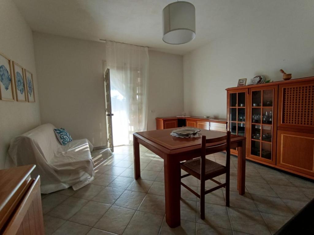 a living room with a wooden table and a chair at Villa Aurora in Ispica