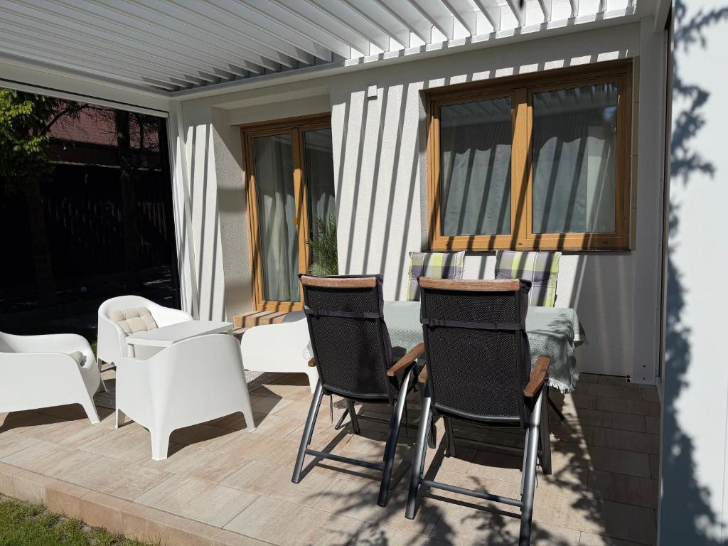 a patio with chairs and a table on a deck at Apartamenty Dana in Pustkowo