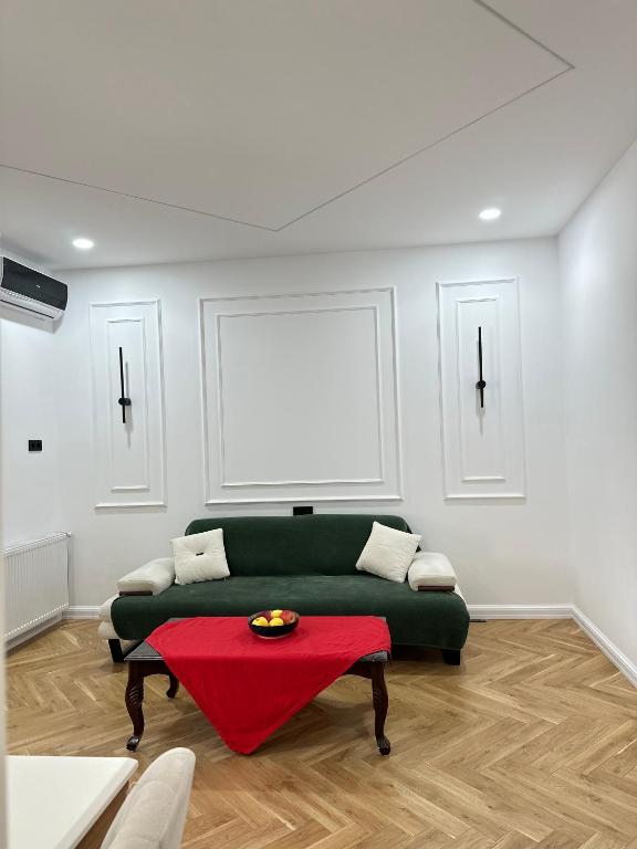 a living room with a green couch and a table at Batumi in Stantsiya Batumi-Passazhirskaya