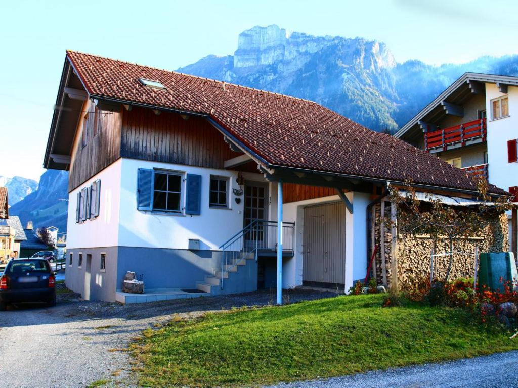 a white house with a mountain in the background at Apartement Johannes in Mellau