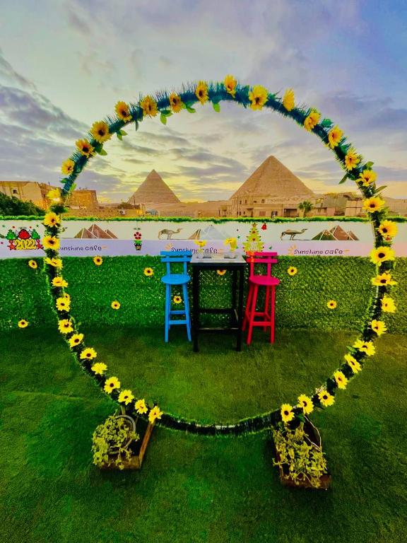 a circle of flowers with two chairs and a table at Sunshine Pyramids Hotel & Restaurant in Cairo