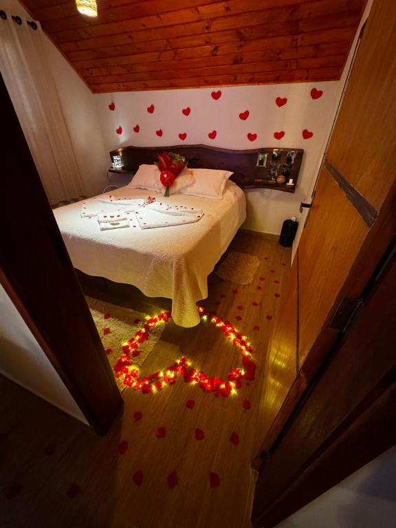a bedroom with a bed with christmas lights on the floor at Chalé Recanto do Quilombo - MV in Camanducaia