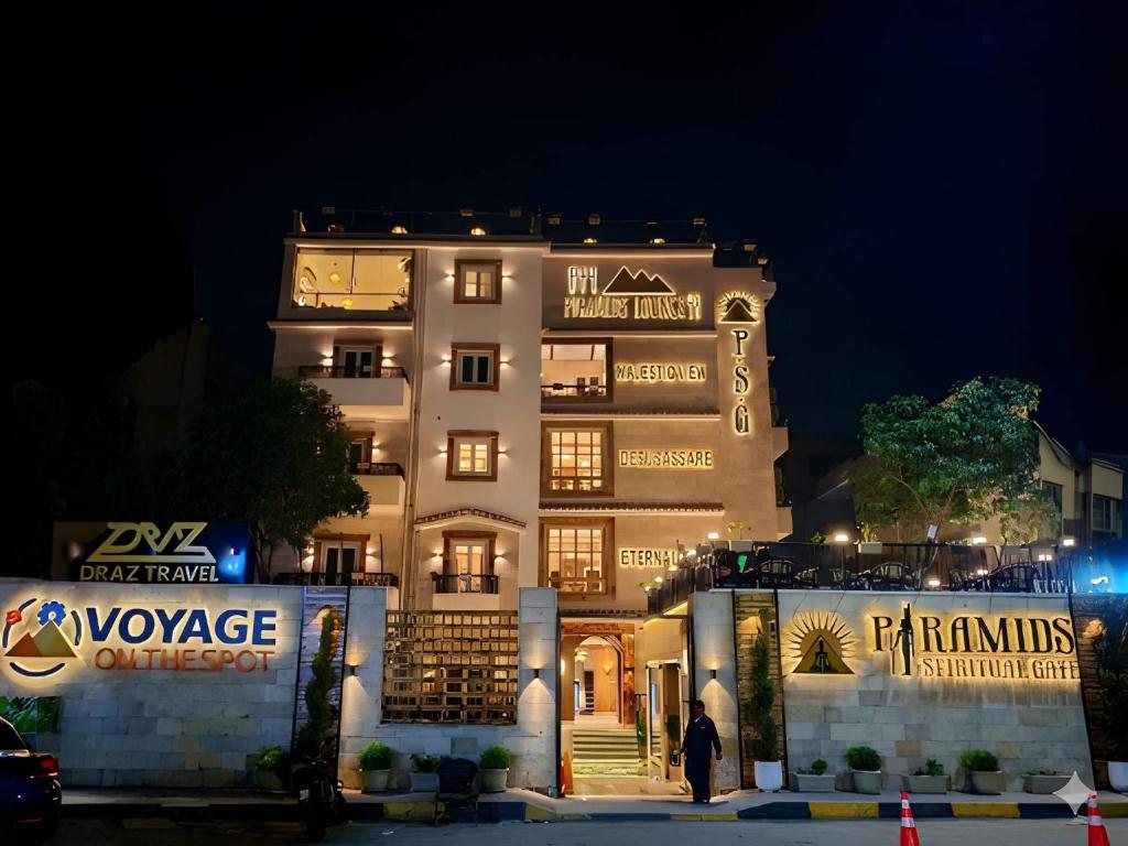 a large white building with lights on it at night at Pyramids Spiritual Hotel in Cairo