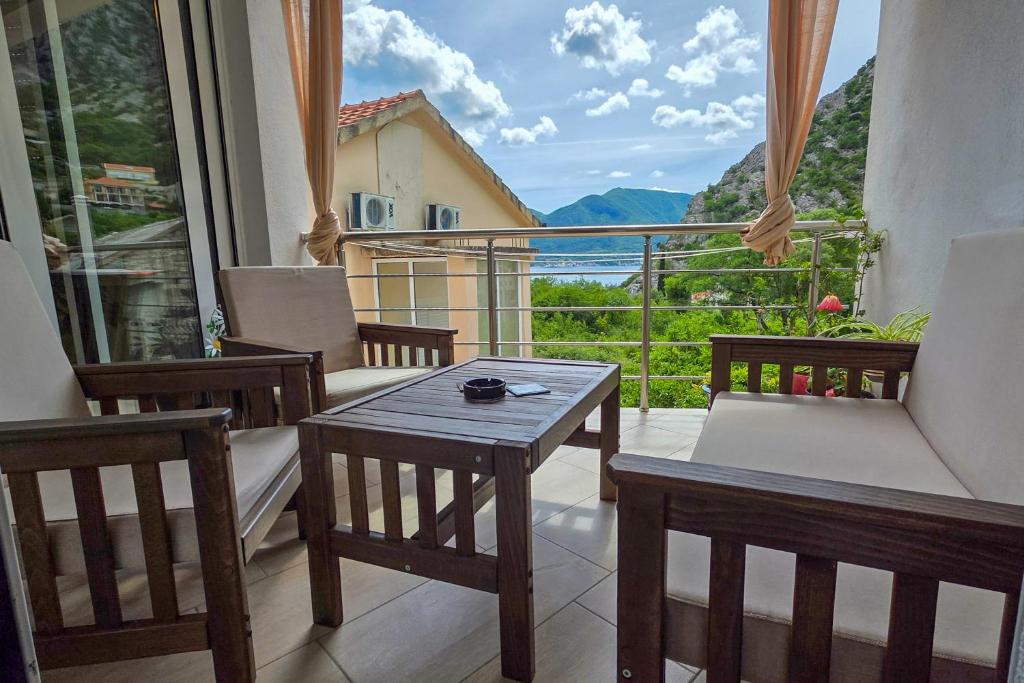 a room with chairs and a table and a balcony at Apartman Darija 3 in Gornji Orahovac
