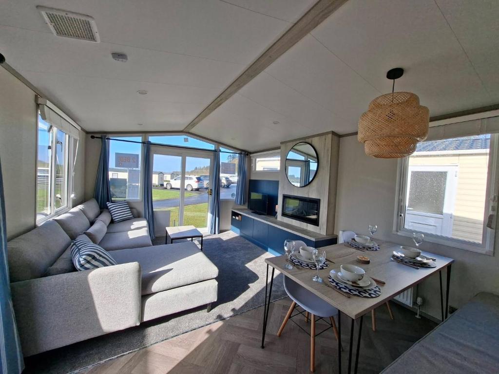 a living room with a couch and a table at Three Lochs Holiday Park, 139 Loch View with Lazy Spa Hot Tub, Platinum 3 bedroom Holiday Home for Hire in Balminnoch