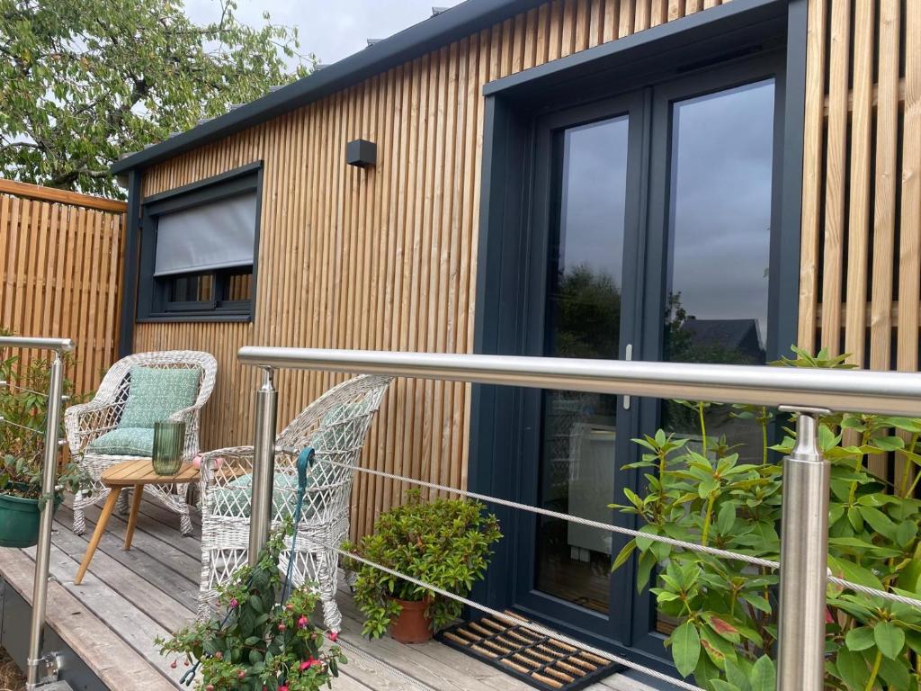 a tiny house with a deck with a chair at Bonamy's in Saint-Ouen