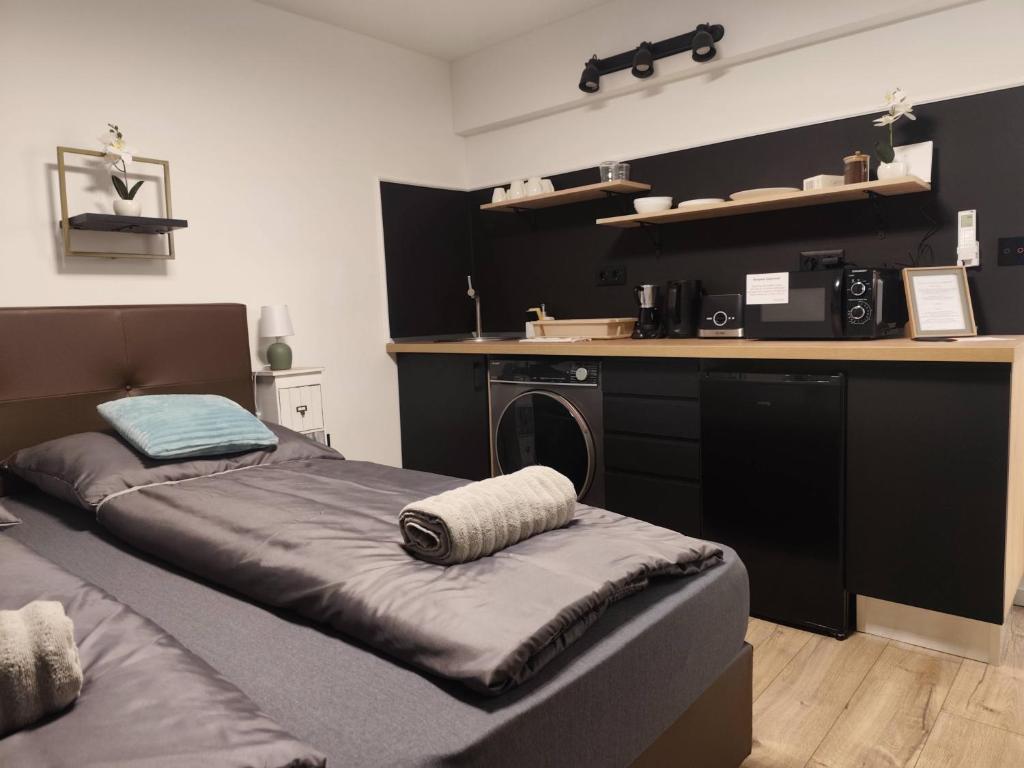 a room with two beds and a kitchen with a counter at B23 Apartman in Harkány