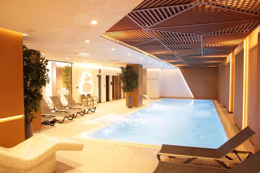 a pool in a hotel with lounge chairs and a swimming pool at Zemun Golax Apartments in Belgrade