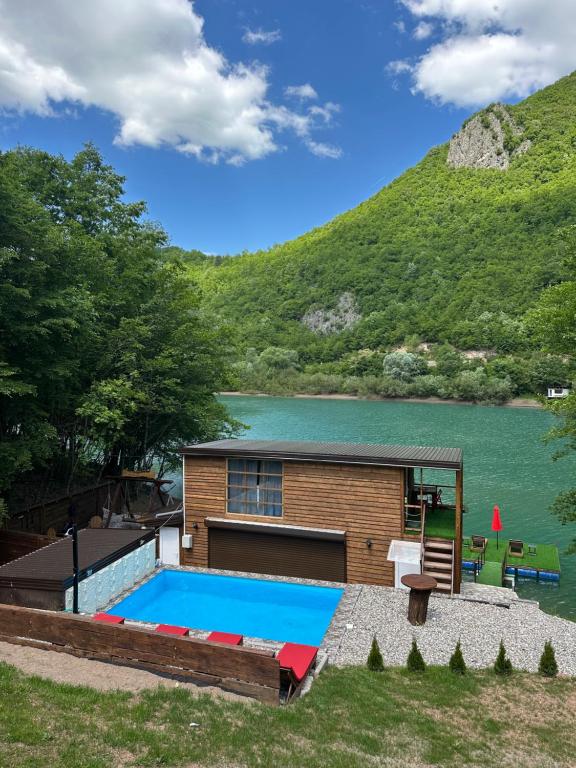a house with a swimming pool next to a lake at Pablo's place in Rezine