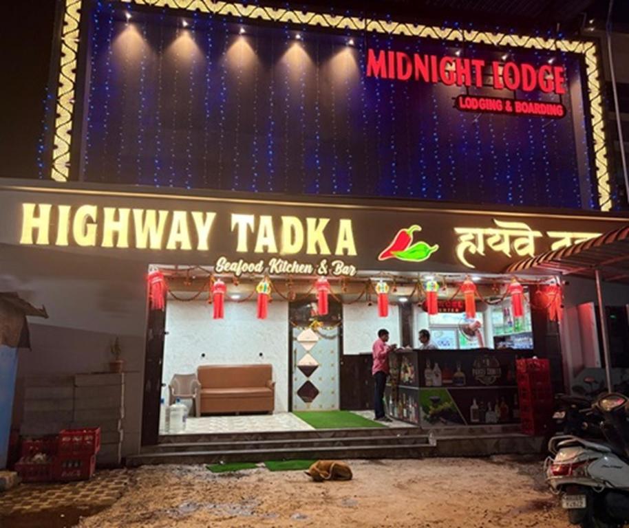 a man standing in front of a highway takaka stage at Hotel Midnight Lodging & Boarding in Panvel