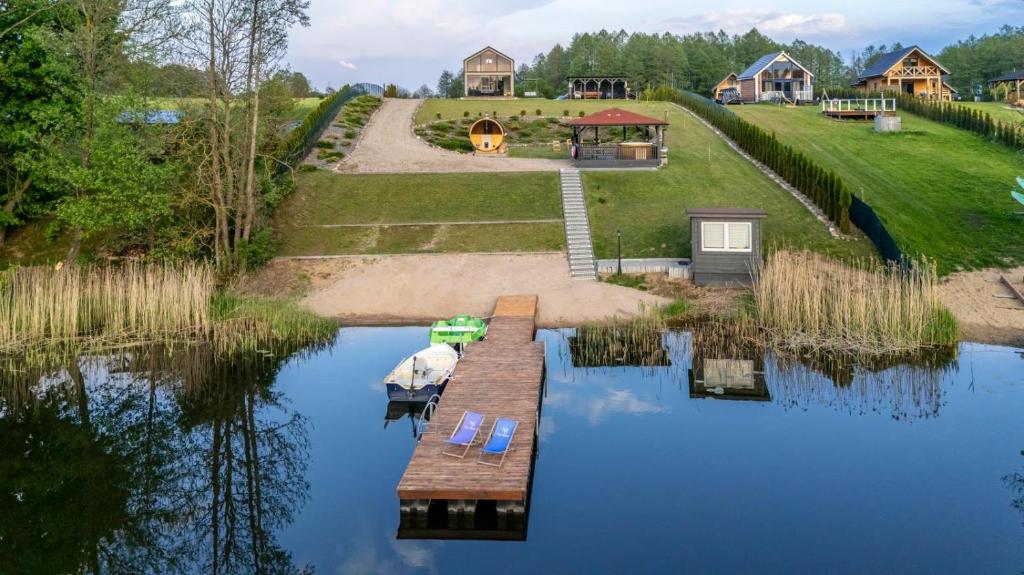 an aerial view of a lake with a dock and a house at Nini House Swietajno in Olecko