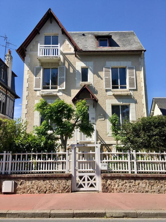 a white fence in front of a house at Villa Myriam in Deauville