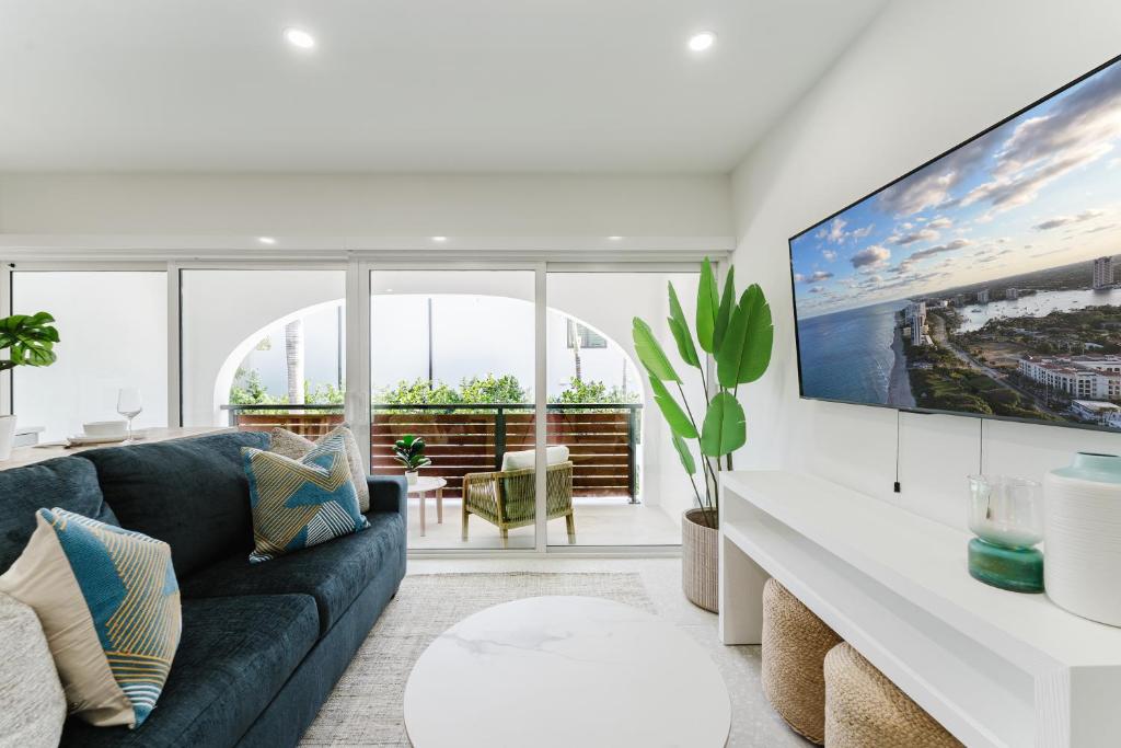 a living room with a couch and a large tv at Villa Verde - Boca Pool & Beach Walk in Boca Raton