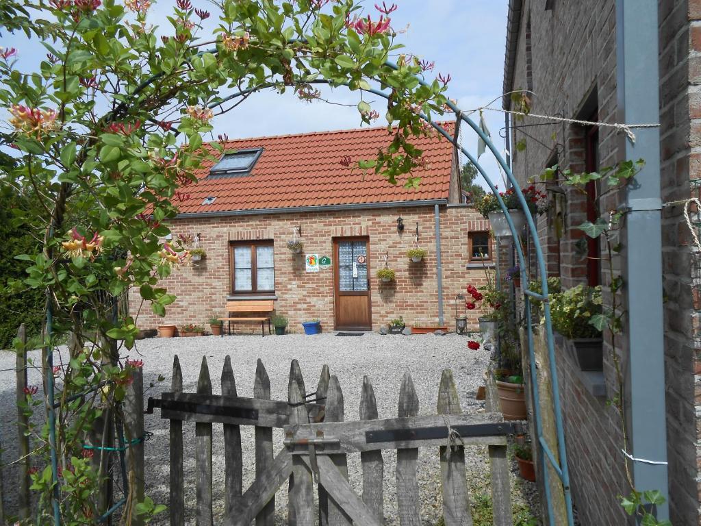 a brick house with a gate and a fence at Les Six Vallées in Ramillies