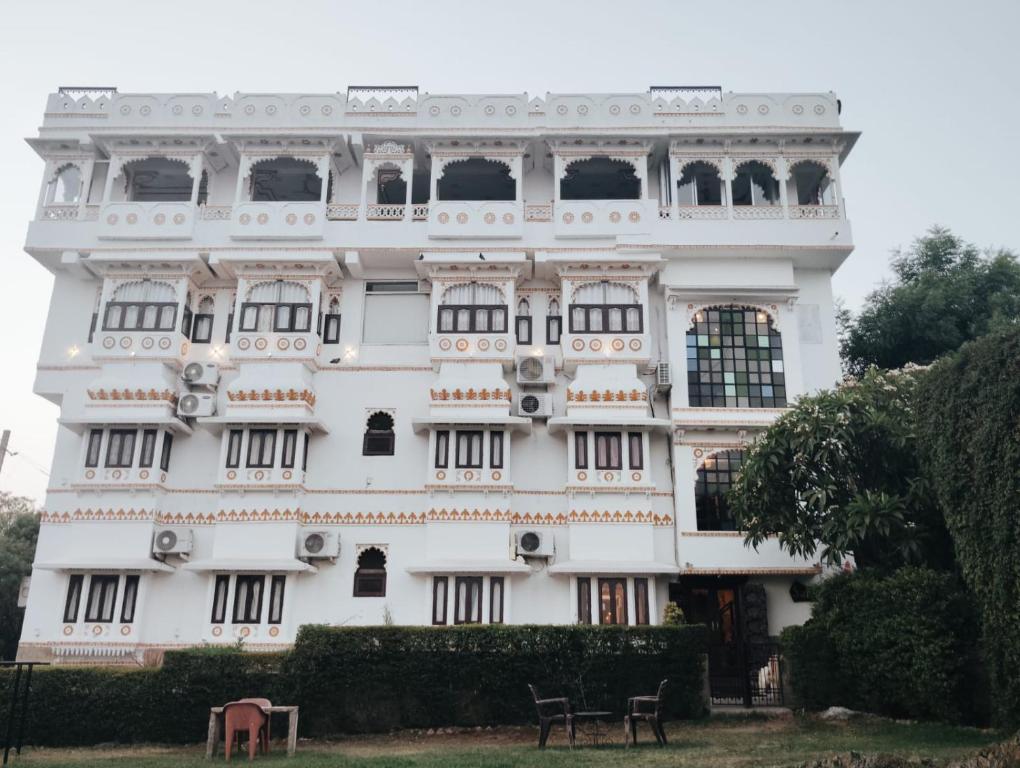 a white building with a lot of windows at hotel sargam sadan in Jāmb