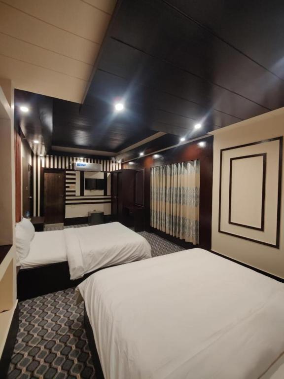 a hotel room with two beds and a kitchen at Sylhet Comfort Stay Hotel in Sylhet