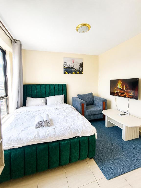 a bedroom with a large green bed and a chair at Modern Nest Studio Kikuyu in Rungiri