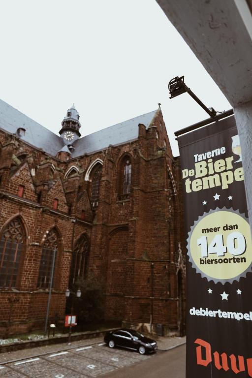 a car parked in front of a large brick building at B&B De Mout in Diest