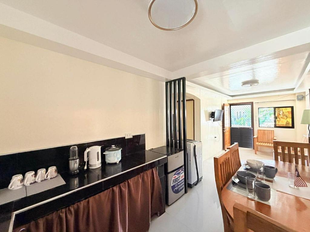 a kitchen with a counter top and a table and chairs at Medecielo Villa in San Fernando