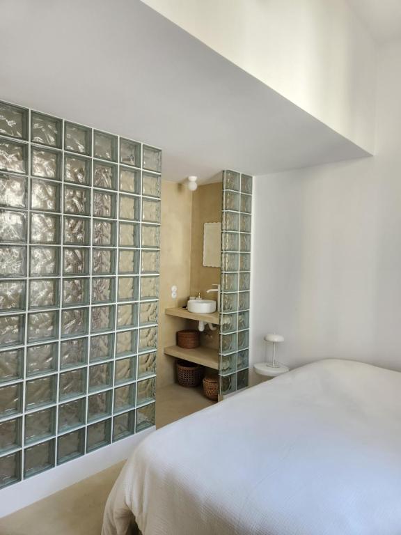 a white bedroom with a wall of glass blocks at Sublime chambre à endoume proche mer in Marseille