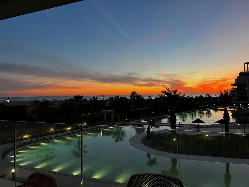 a large swimming pool with a sunset in the background at Ocean Homes, Vista Mar y piscina EXCELLENT & SOLMARES in Punta del Caimán