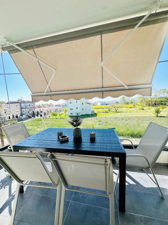 a blue table and two white chairs on a patio at Fanari Meltemi Apartment in Fanari