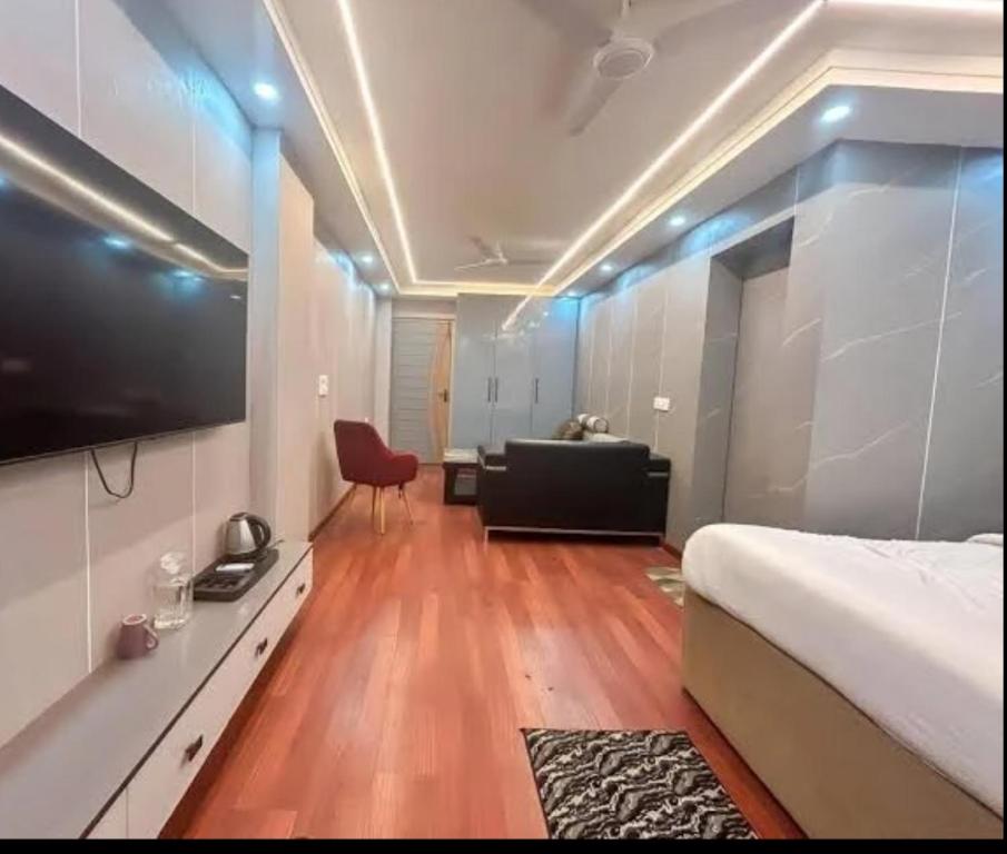a bedroom with a bed and a television on a wall at Blueberry Premium Hotel in Greater Noida