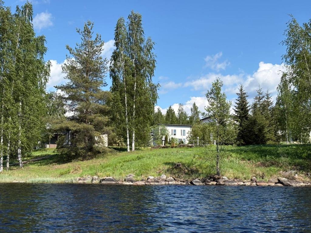 a house on a hill next to a body of water at Sun Villa in Imatra