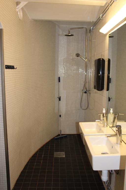 a bathroom with a sink and a shower at Hostel Dalagatan in Stockholm
