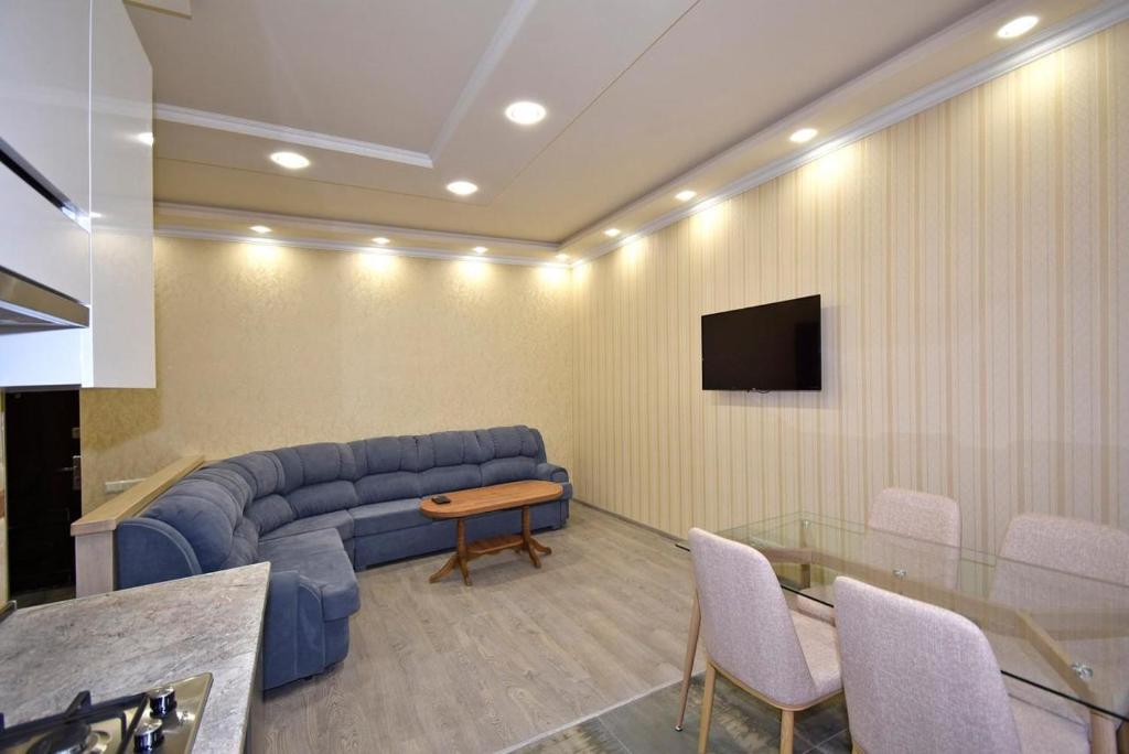 a living room with a blue couch and a table at Рядом с метро in Yerevan
