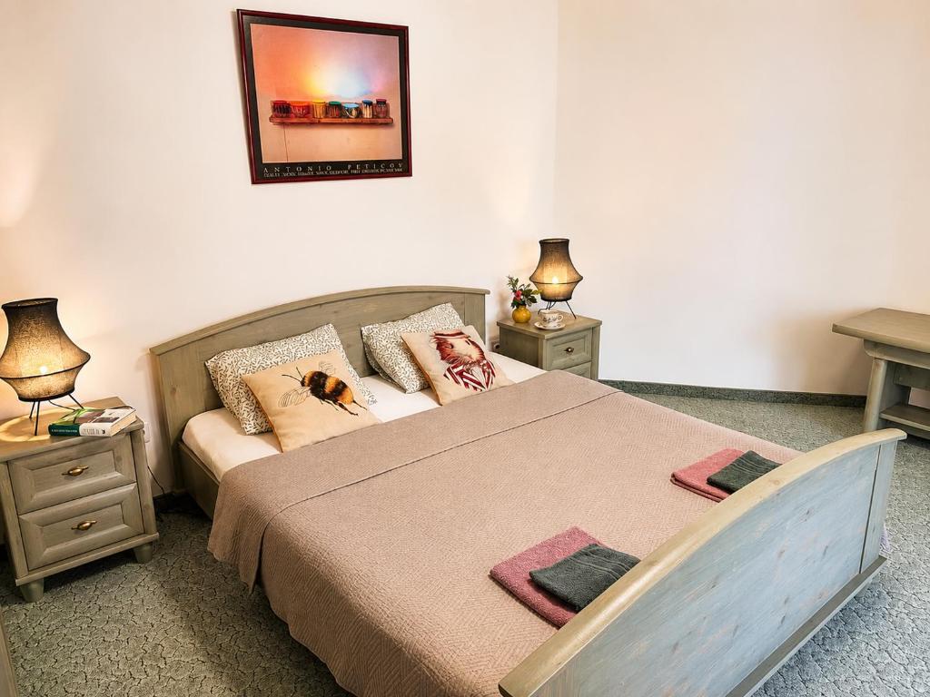 a bedroom with a bed with two tables and a mirror at Éden Panzio in Bük