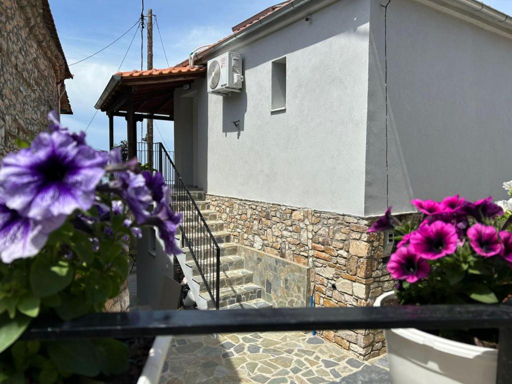 a house with purple flowers on a balcony at Soleil House Thassos in Kallirákhi