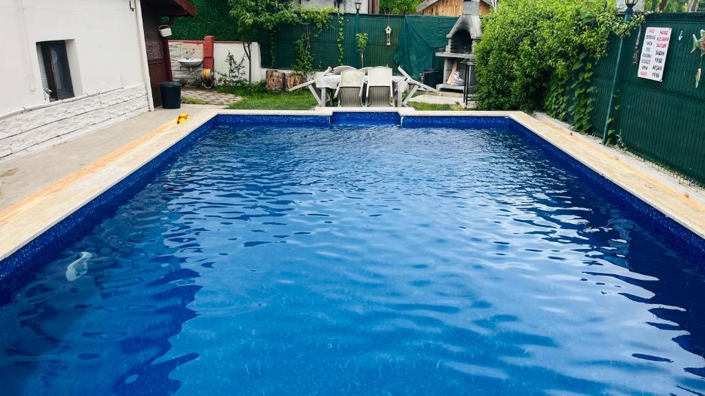 a swimming pool with blue water in a yard at Sapanca Eren Villa-Isıtma Havuzlu in Sapanca