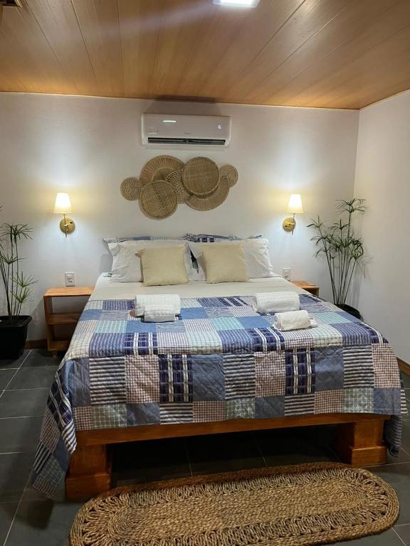 a bedroom with a bed with a blue and white blanket at Casa bambu atins in Atins