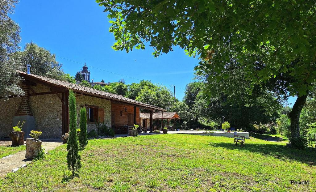 a building with a bench in front of a yard at Casa das Devesas in Caldelas