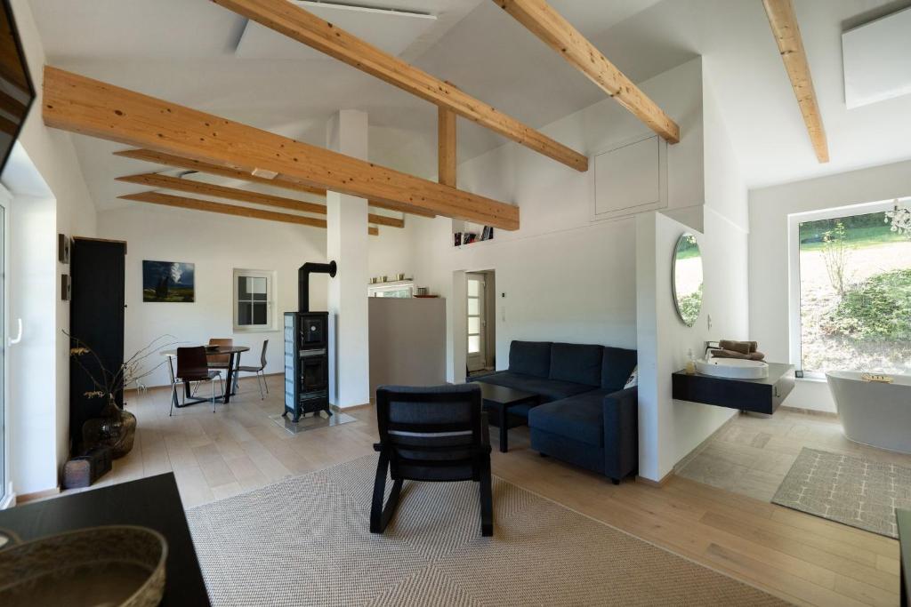 ein Wohnzimmer mit einer blauen Couch und eine Küche in der Unterkunft WaldLoft - Südsteiermark in Heimschuh