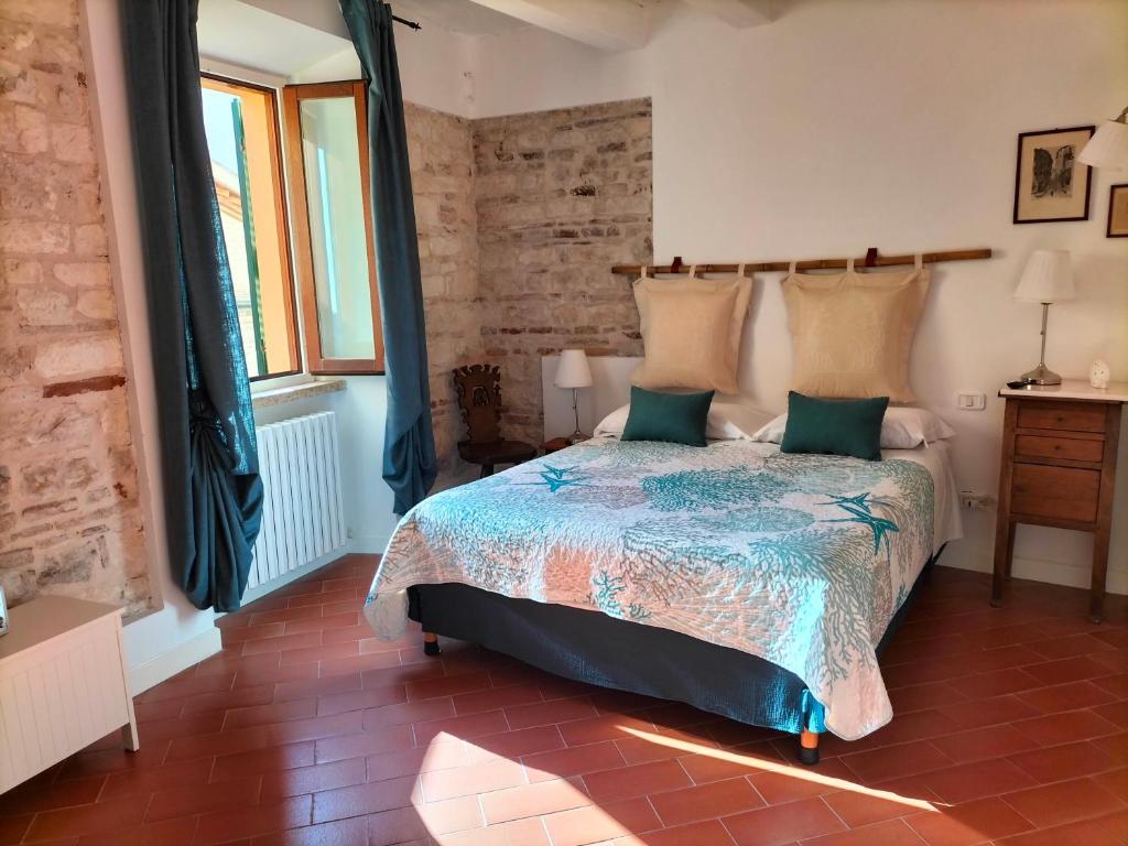 a bedroom with a bed and a brick wall at LA CONCHIGLIA - Sirolo Suite in Sirolo