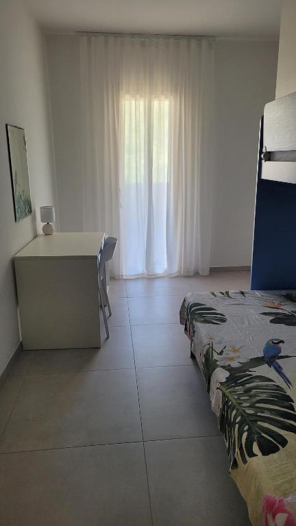 a bedroom with a desk and a bed and a window at Casa Irene in Villasimius