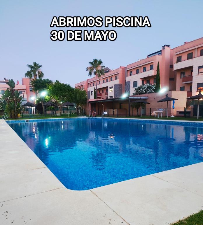 a large swimming pool in front of a building at Elegante apartamento con piscina A un paso de Sevilla San Miguel in Camas