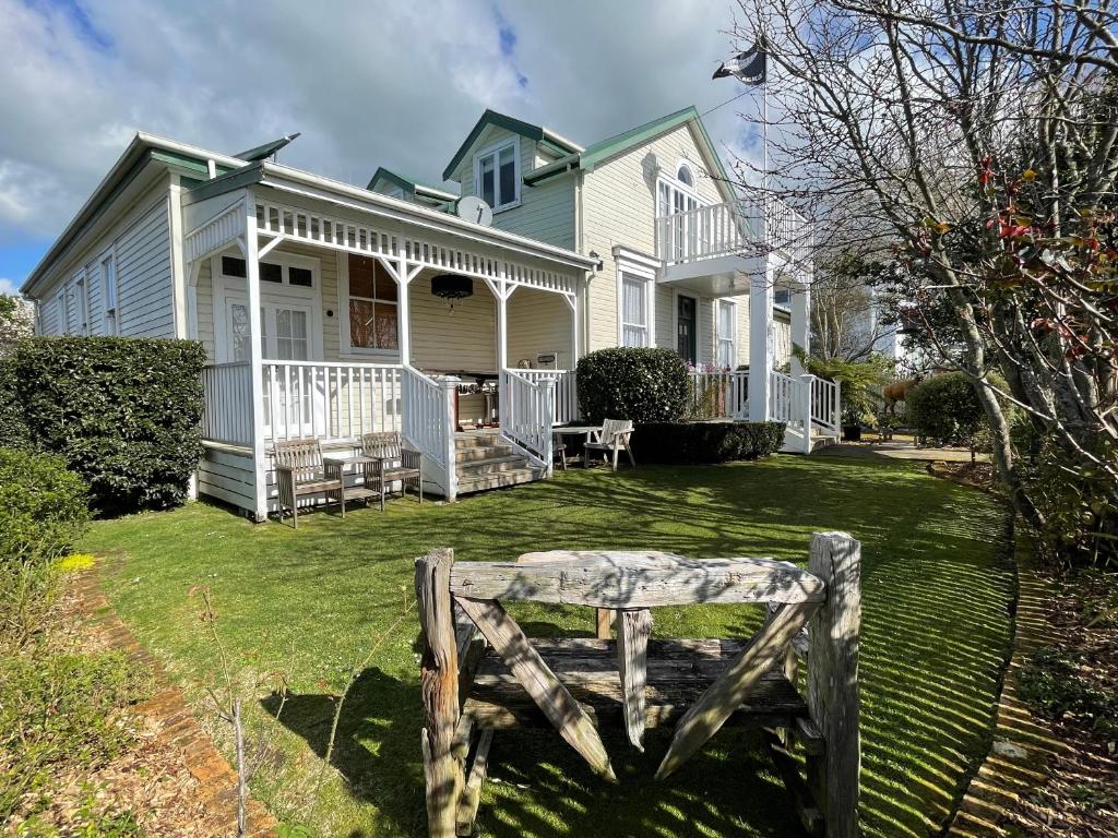 a house with a wooden bench in the yard at Rose Lodge Bed & Breakfast in Tirau